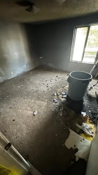 Bedroom with burned flooring and smoke-stained walls