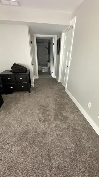 Carpeted room with a doorway to the bathroom
